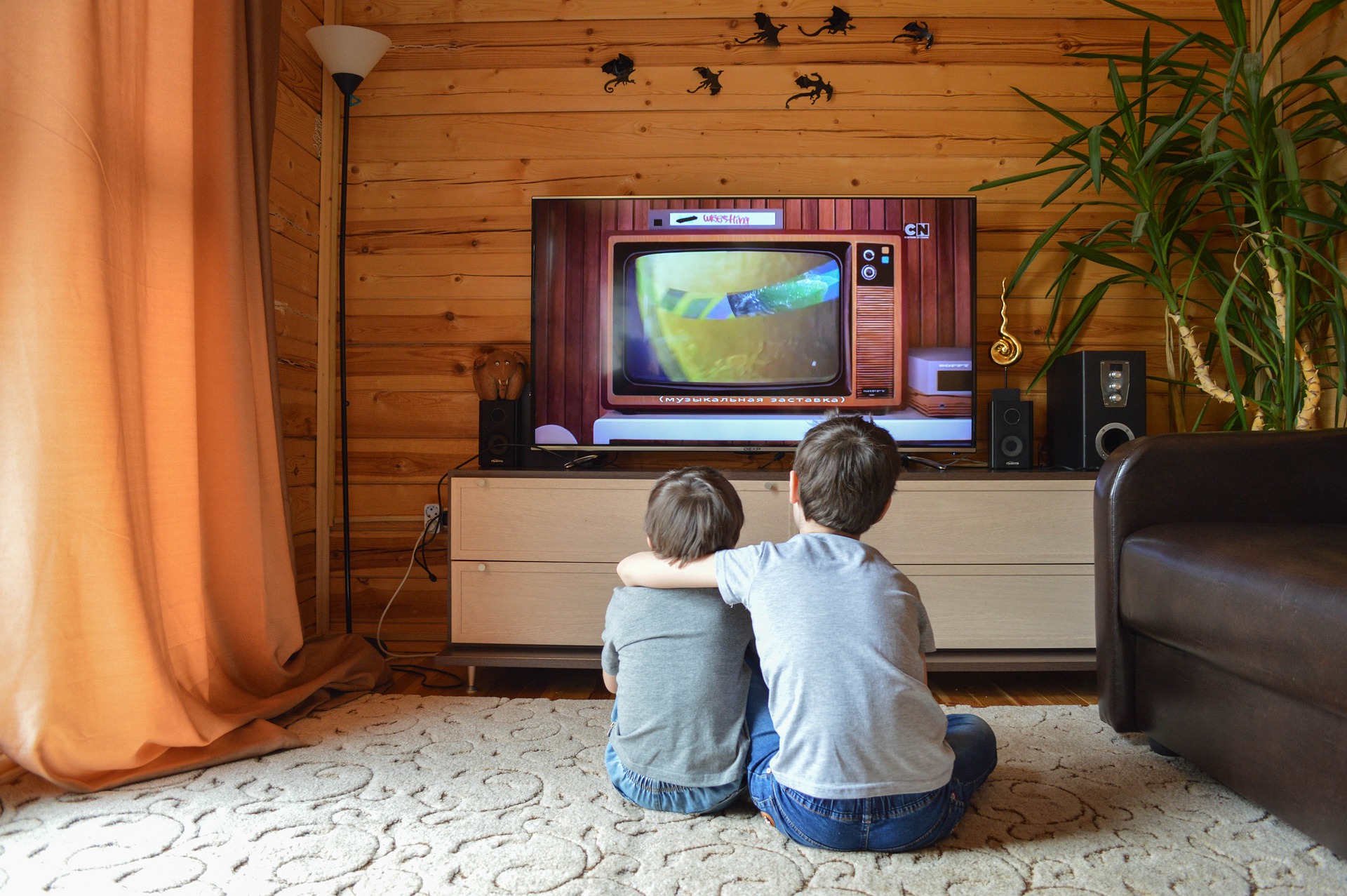 Dos niños abrazados viendo la televisión
